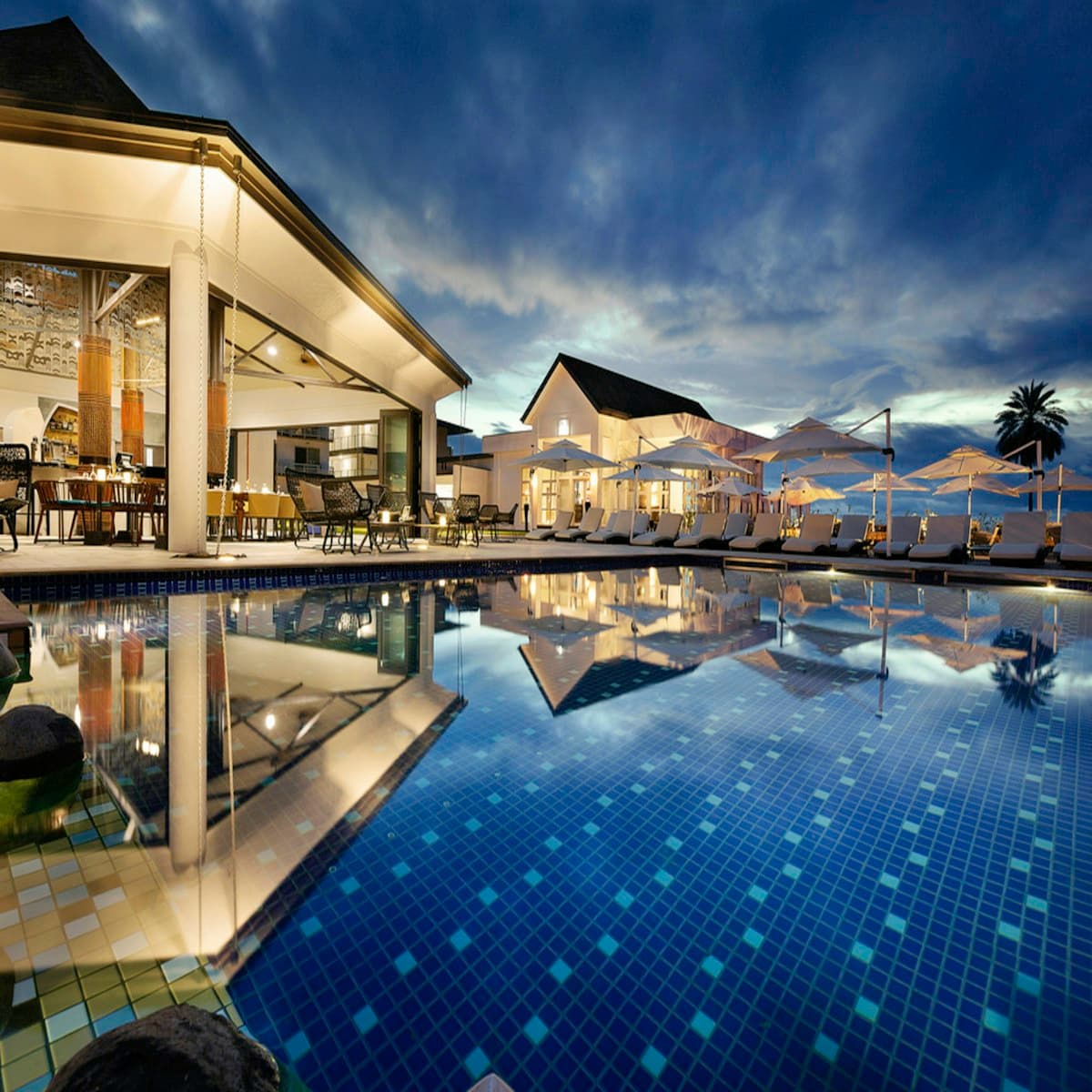 A hotel pool and terrace at dusk